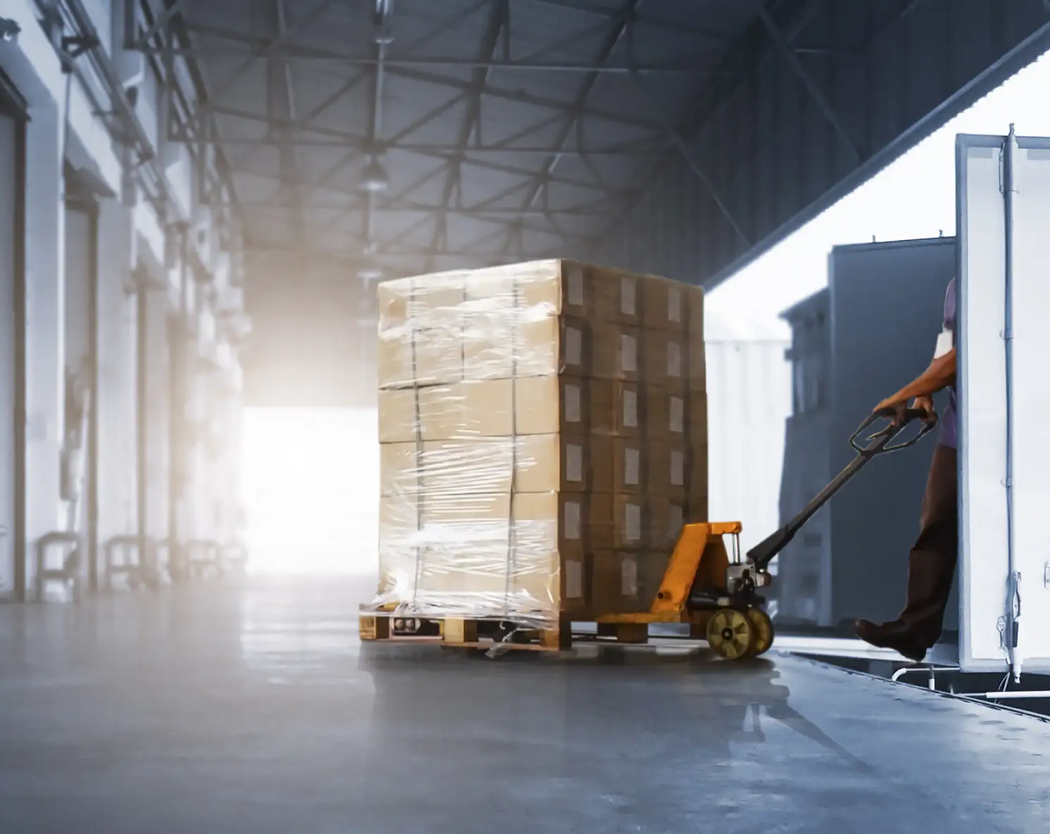Elye Distribution – Loading Dock Pallet Handling Operator moving a wrapped pallet with a pallet jack at a warehouse loading dock.