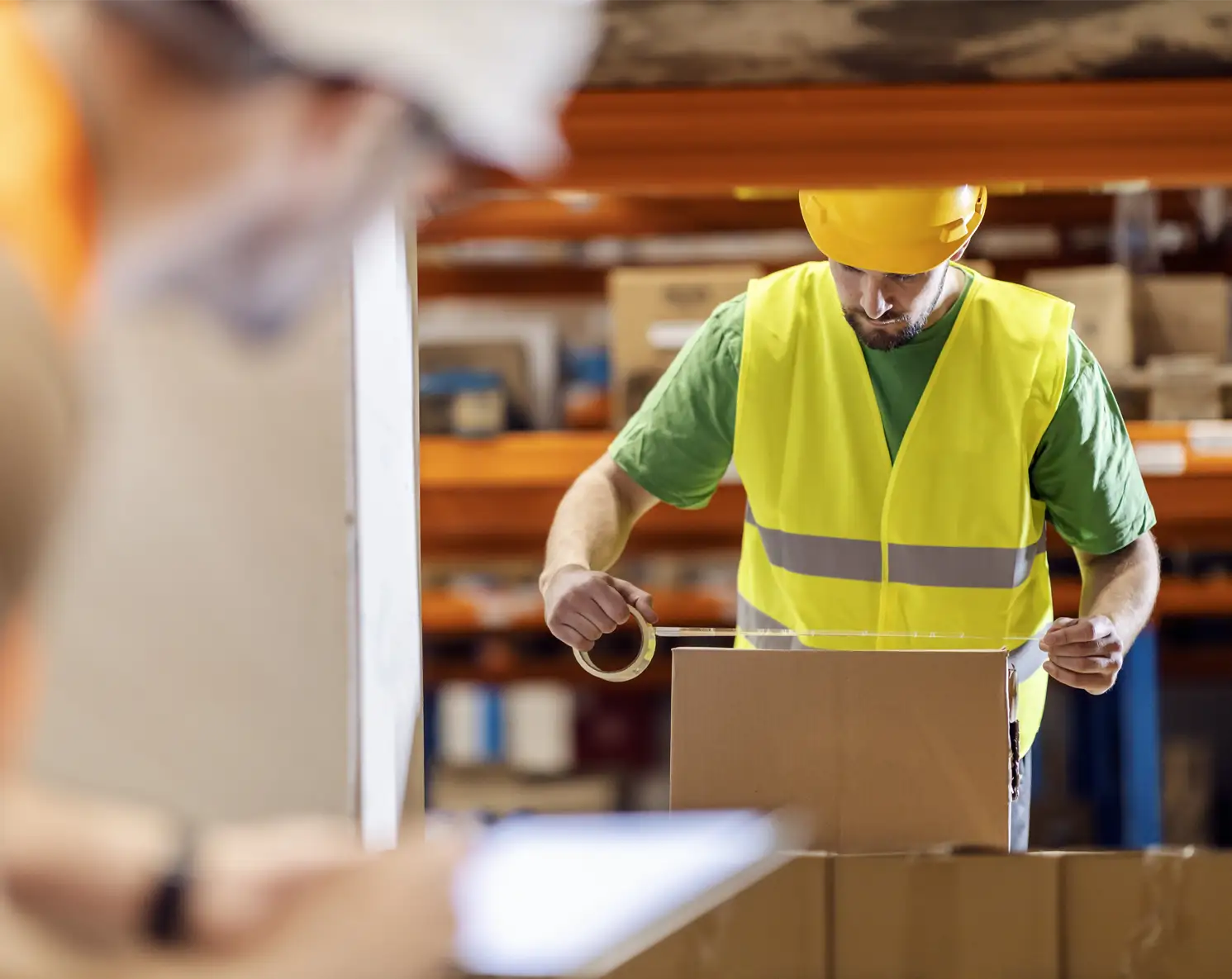 Professional warehouse staff preparing and sealing packages inside Elye Distribution’s logistics facility